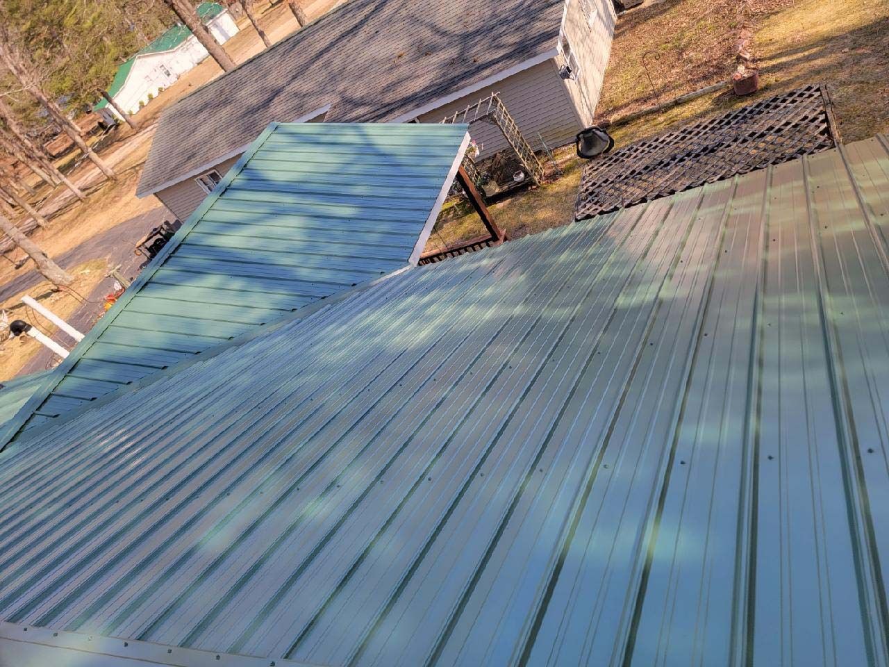 A green metal roof is sitting on top of a house.