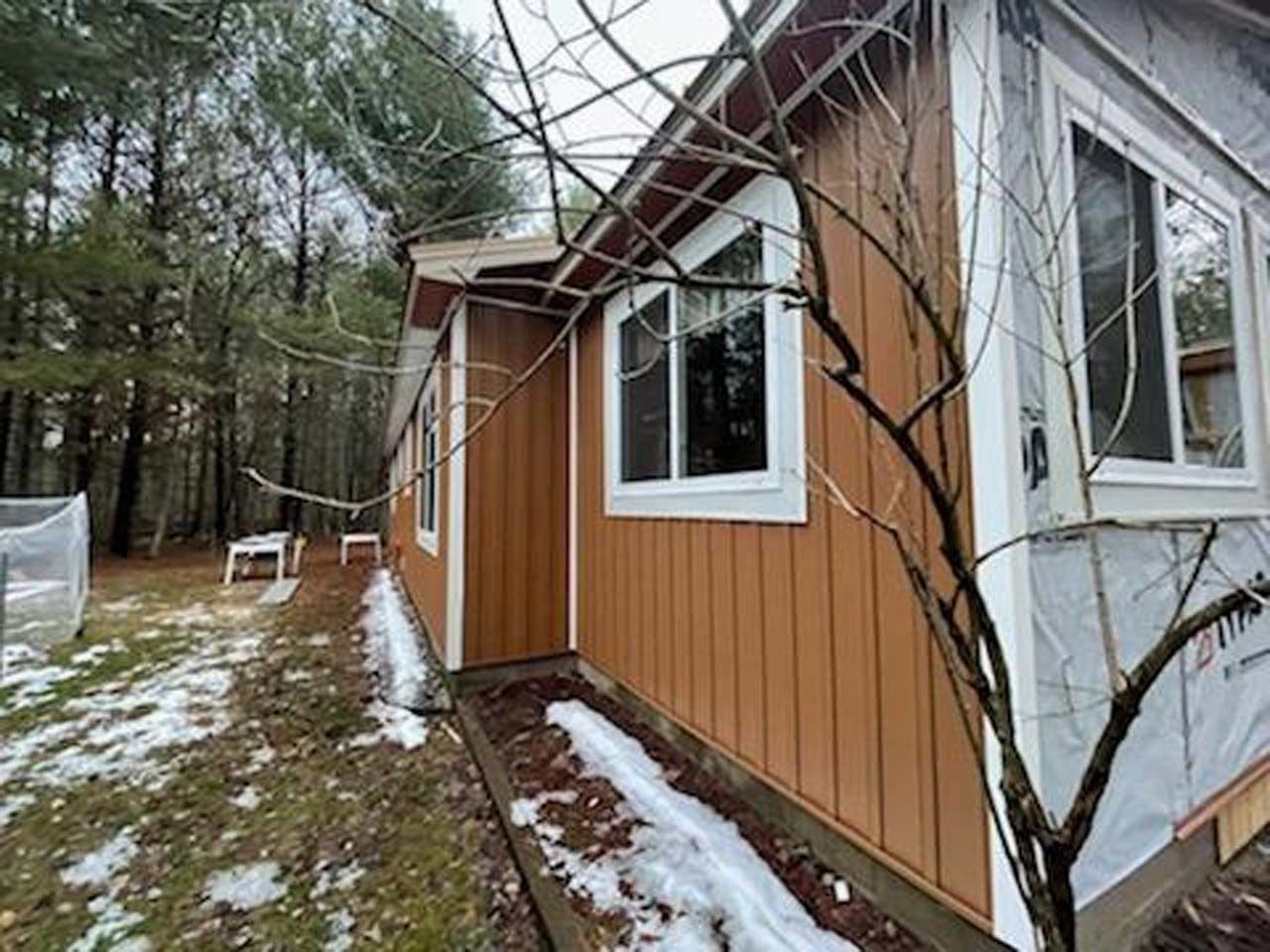 A house with a lot of windows and a tree in front of it.