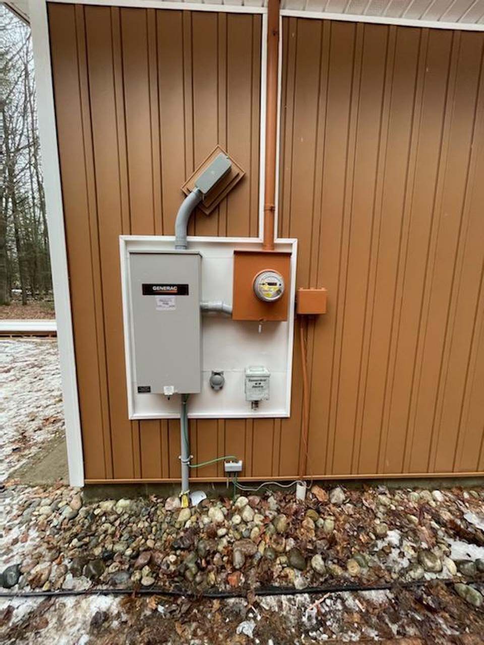 There is a electrical box on the side of a building.