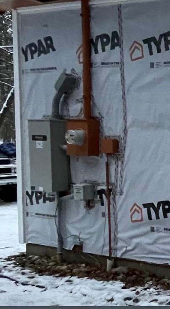 A ypar electrical box is on the side of a building