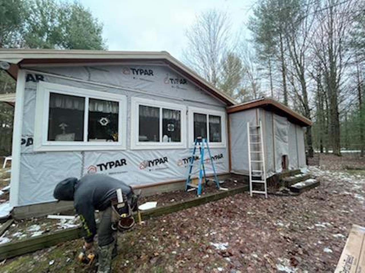 A man is working on the side of a house.