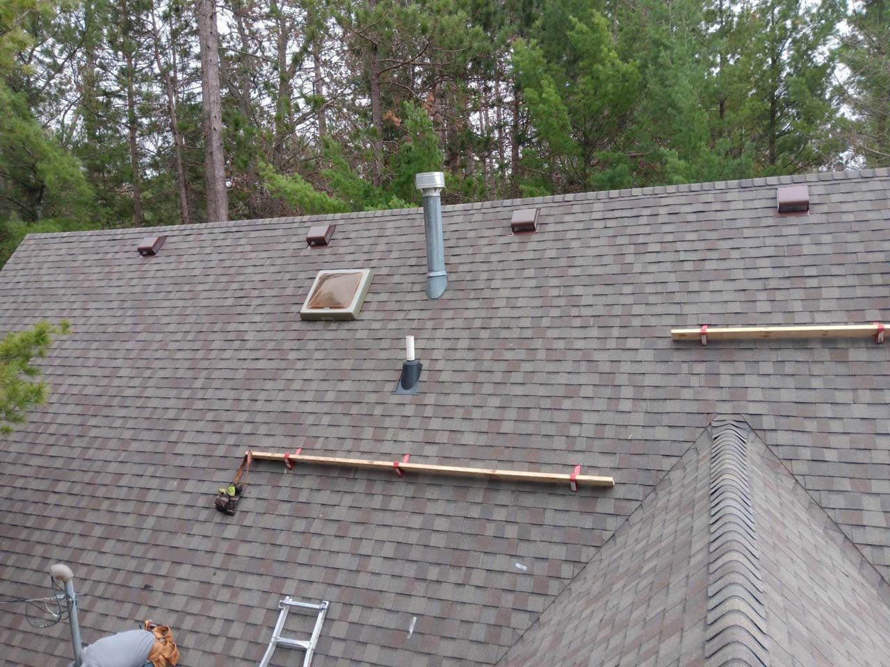 A man is working on the roof of a house.