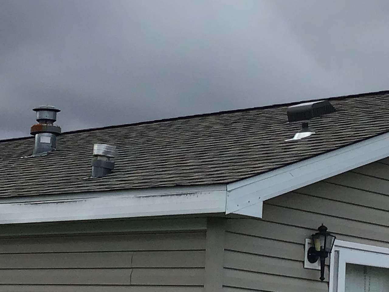 A house with a roof that has a chimney on it.