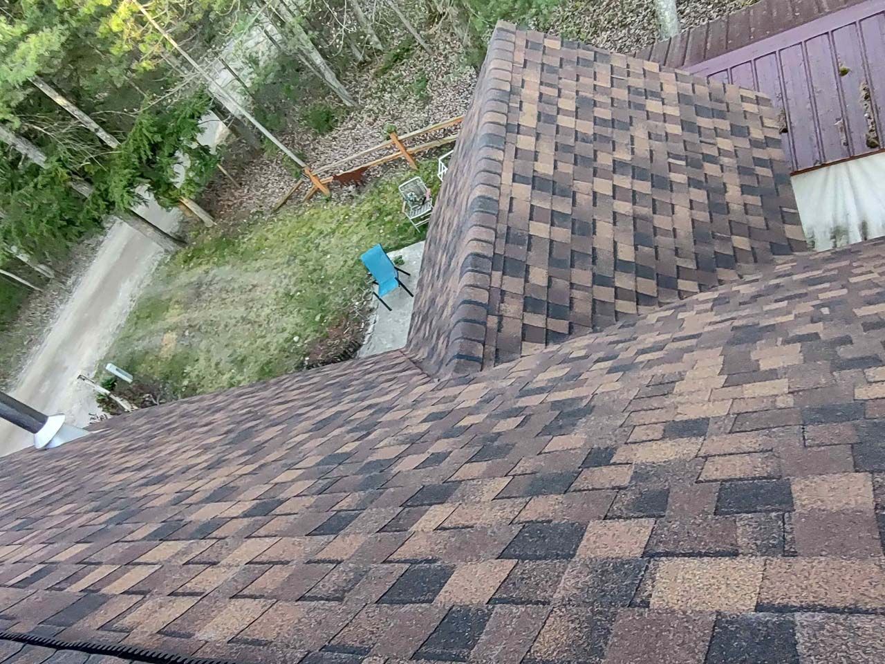 An aerial view of a roof with shingles and a chimney.