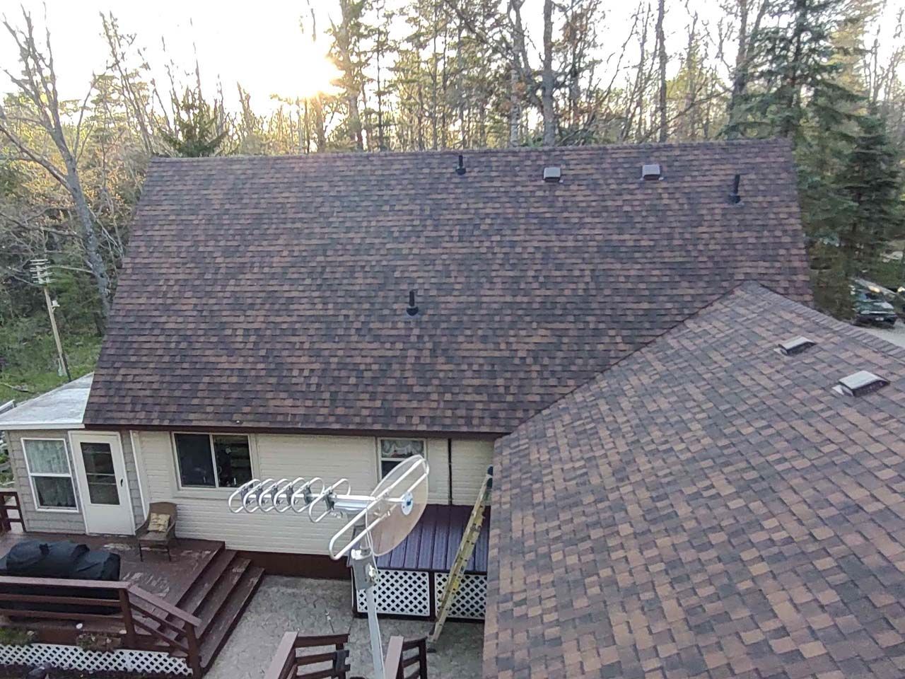 An aerial view of a house with a satellite dish on the roof.
