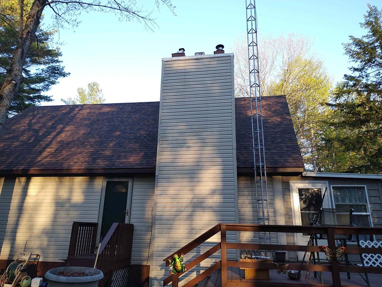 A house with a chimney and a ladder on the roof