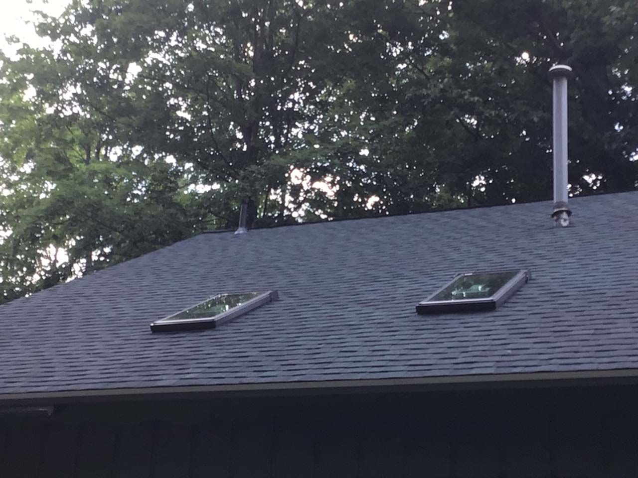 There are two skylights on the roof of a house.