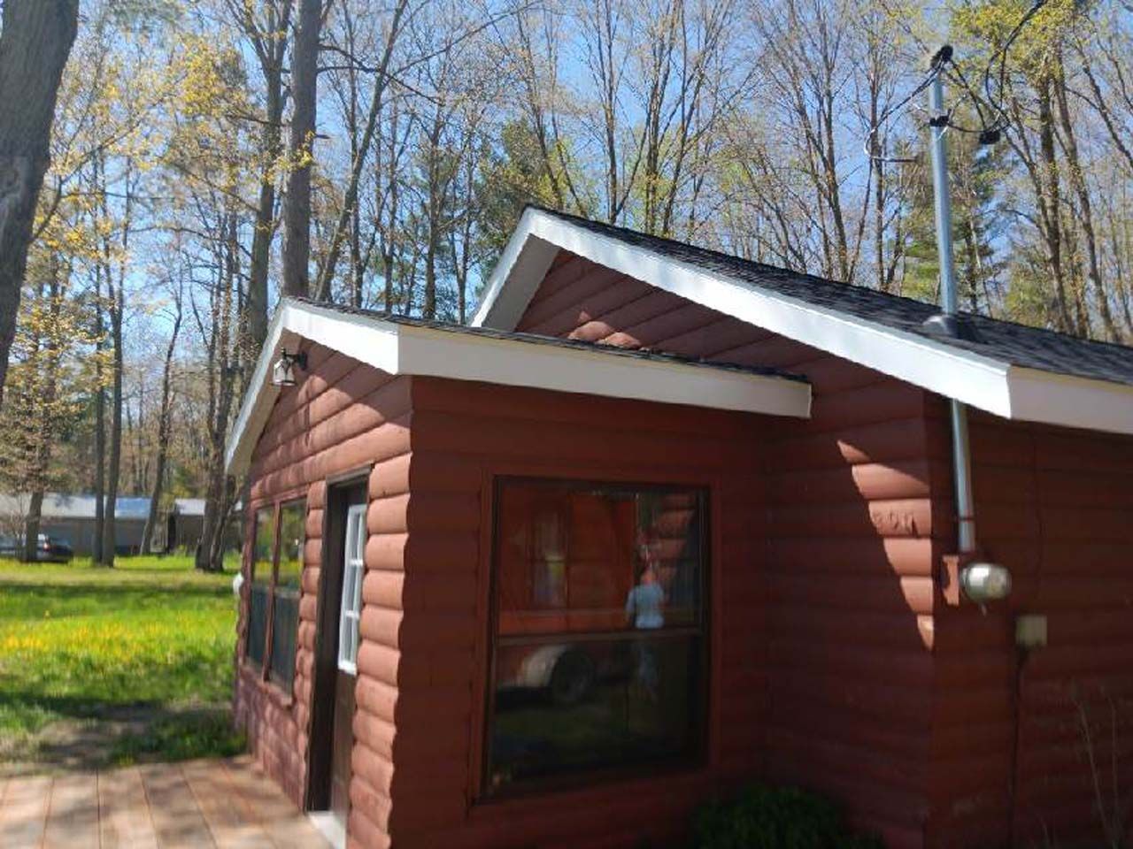 A small log cabin in the middle of a forest.