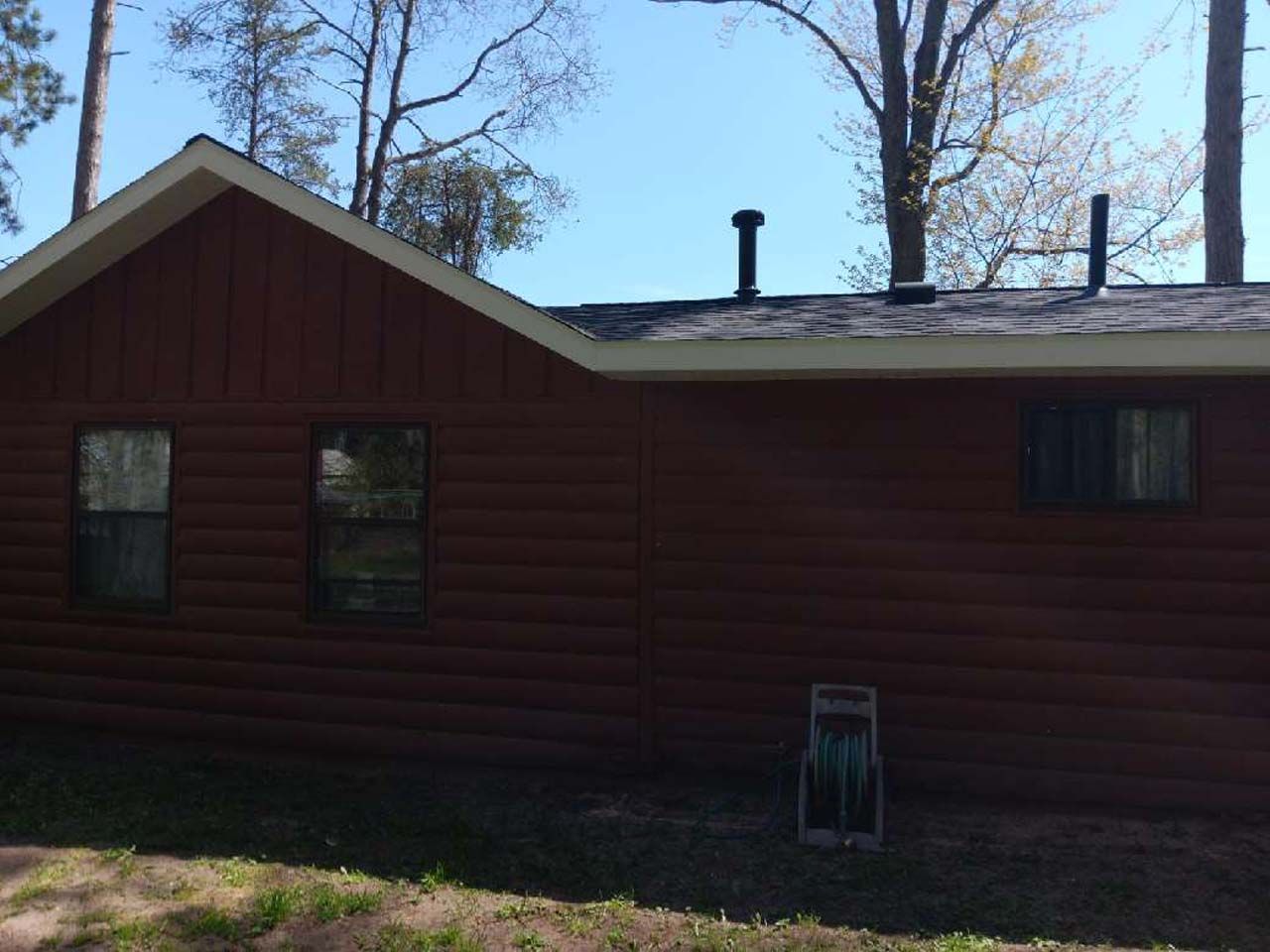 A log cabin with a roof that has a chimney on it