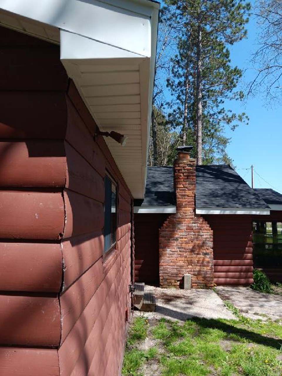 A log cabin with a chimney on the side of it