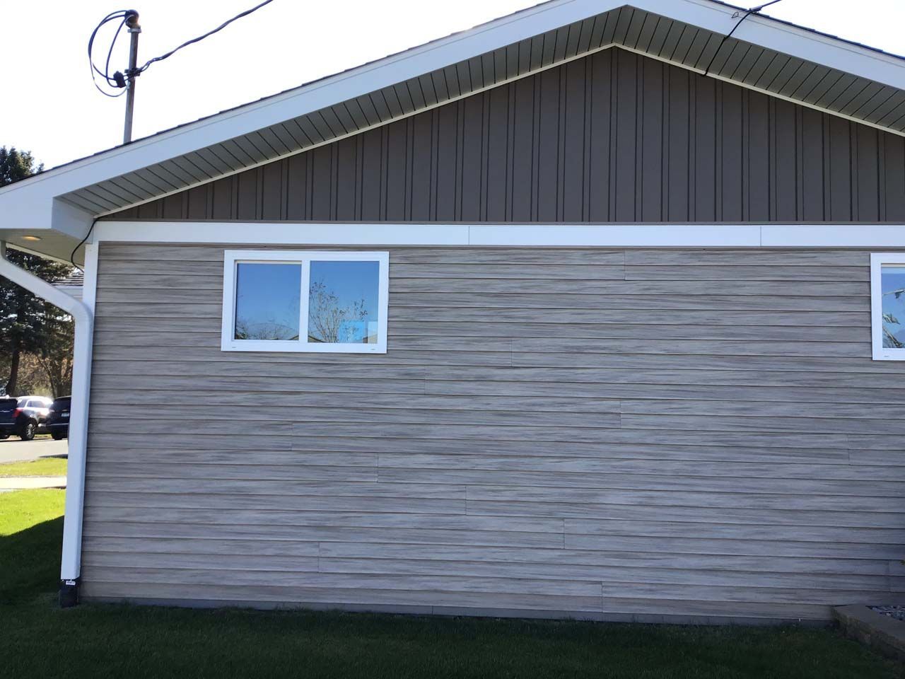 The side of a house with two windows and a roof
