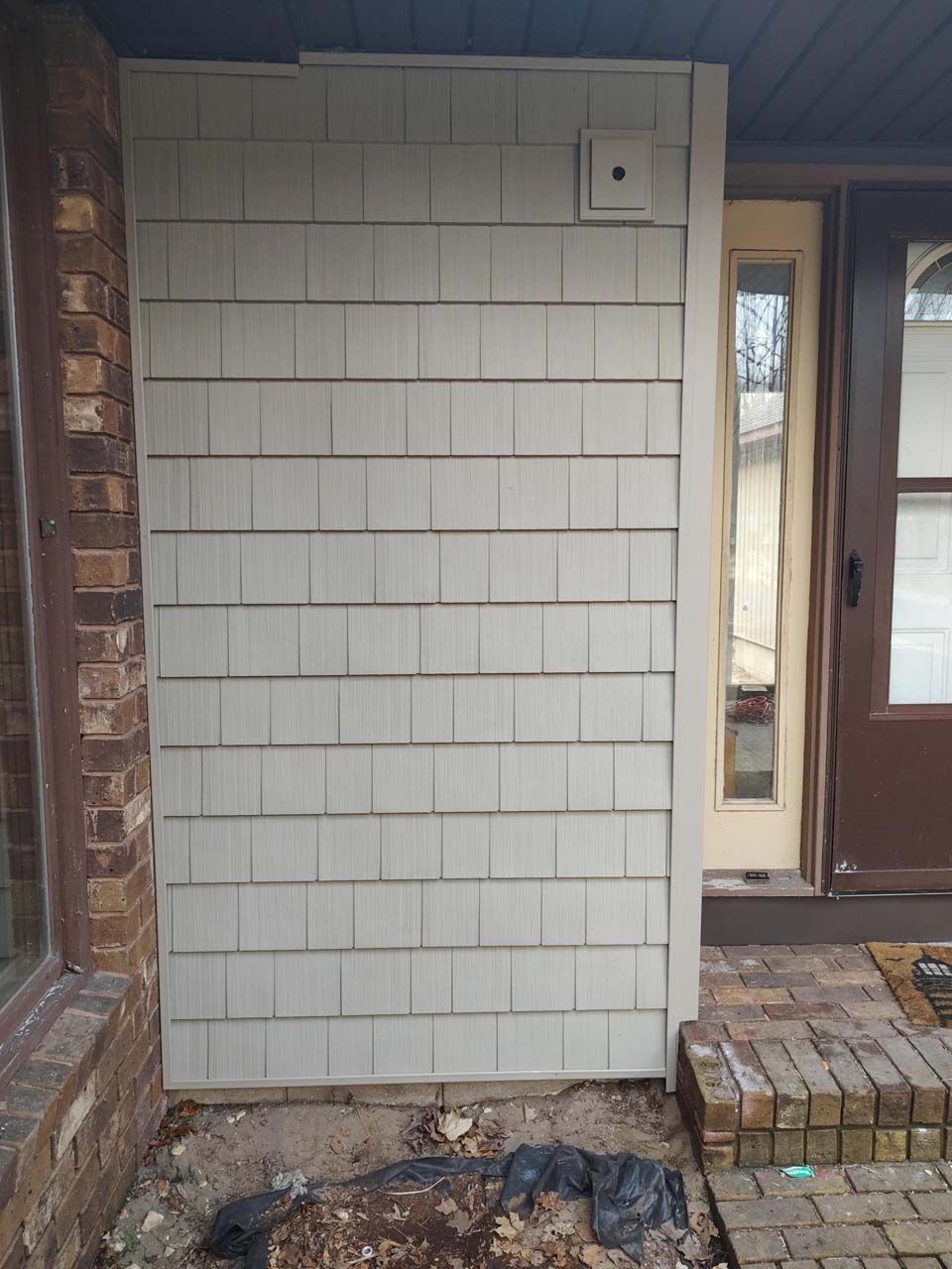 A house with a white siding and a brown door