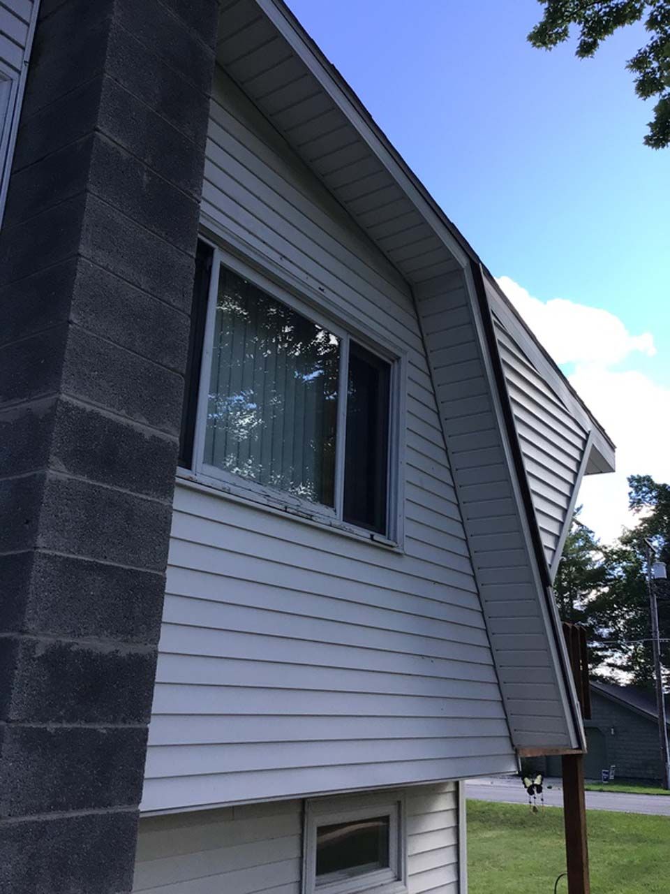 A white house with a black chimney on the side