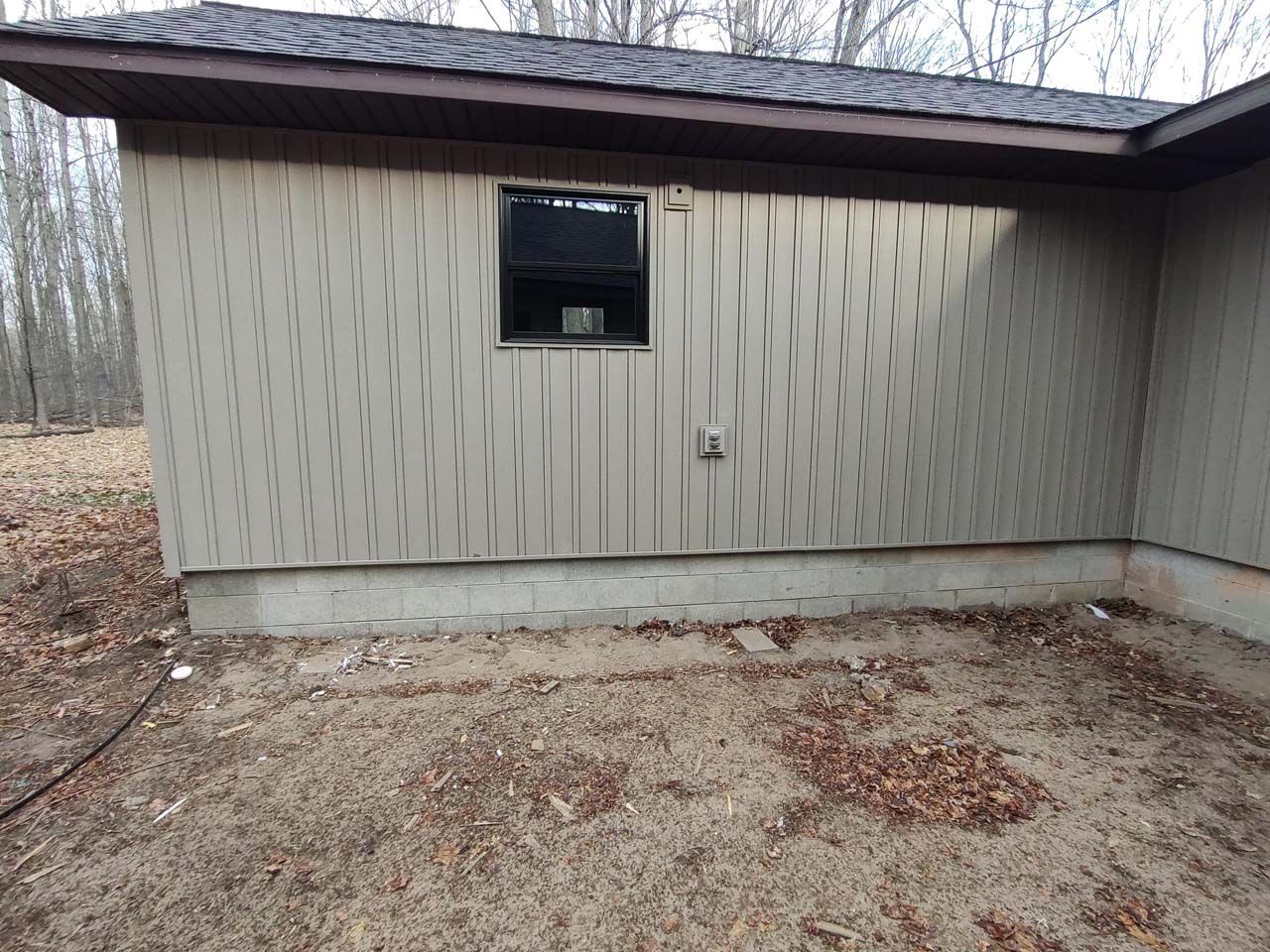 A shed with a window on the side of it.
