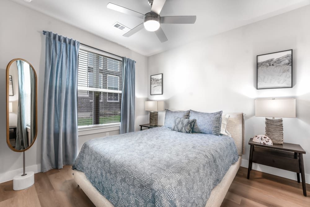Apartment bathroom with two sinks, a toilet, and a large mirror at The Gabriel, which offers Leander apartments for rent.