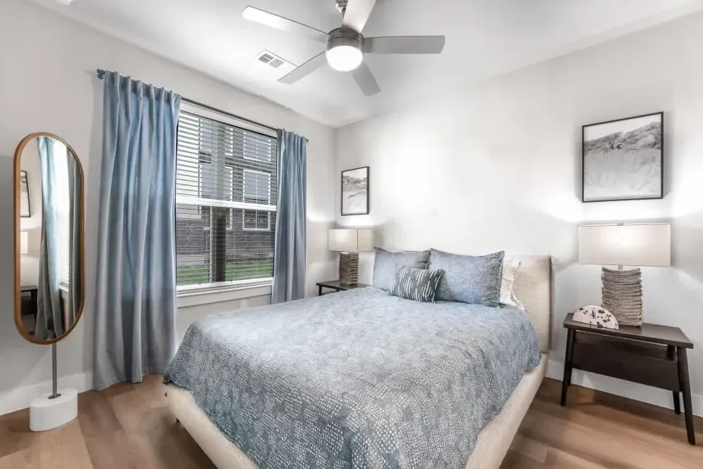 Apartment bathroom with two sinks, a toilet, and a large mirror at The Gabriel, which offers Leander apartments for rent.