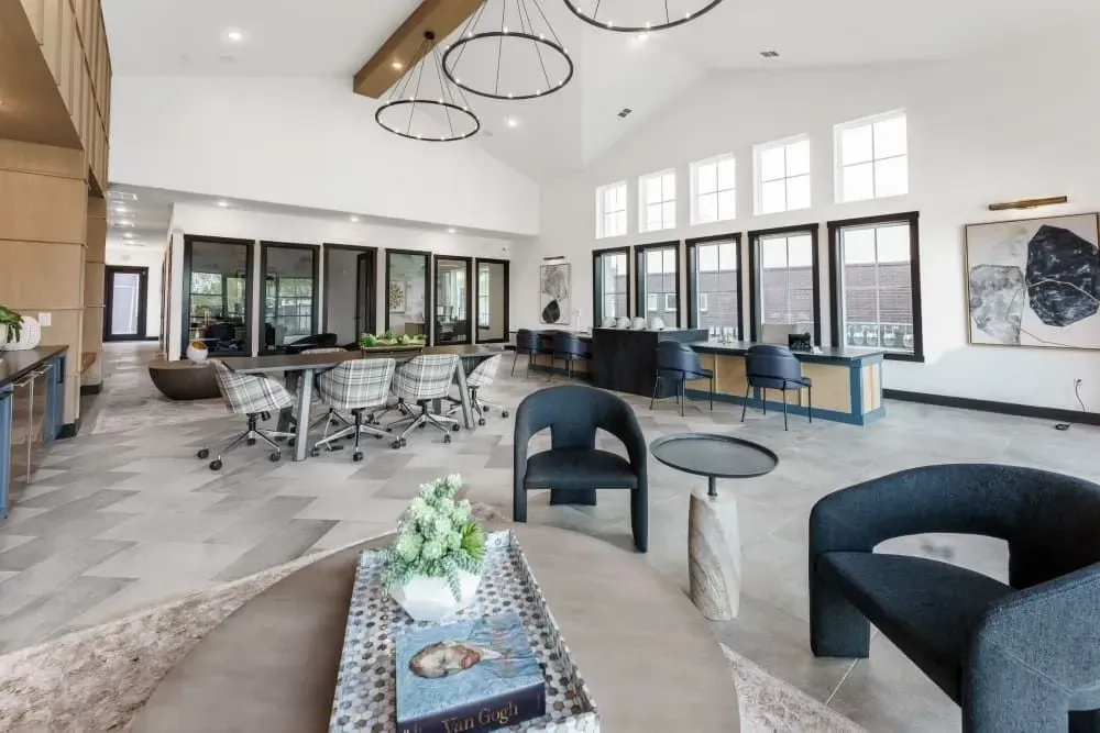 Spacious business center with a couch, chairs, tables, and a desk at The Gabriel, which offers Cedar Park, TX apartments for rent near The Domain.