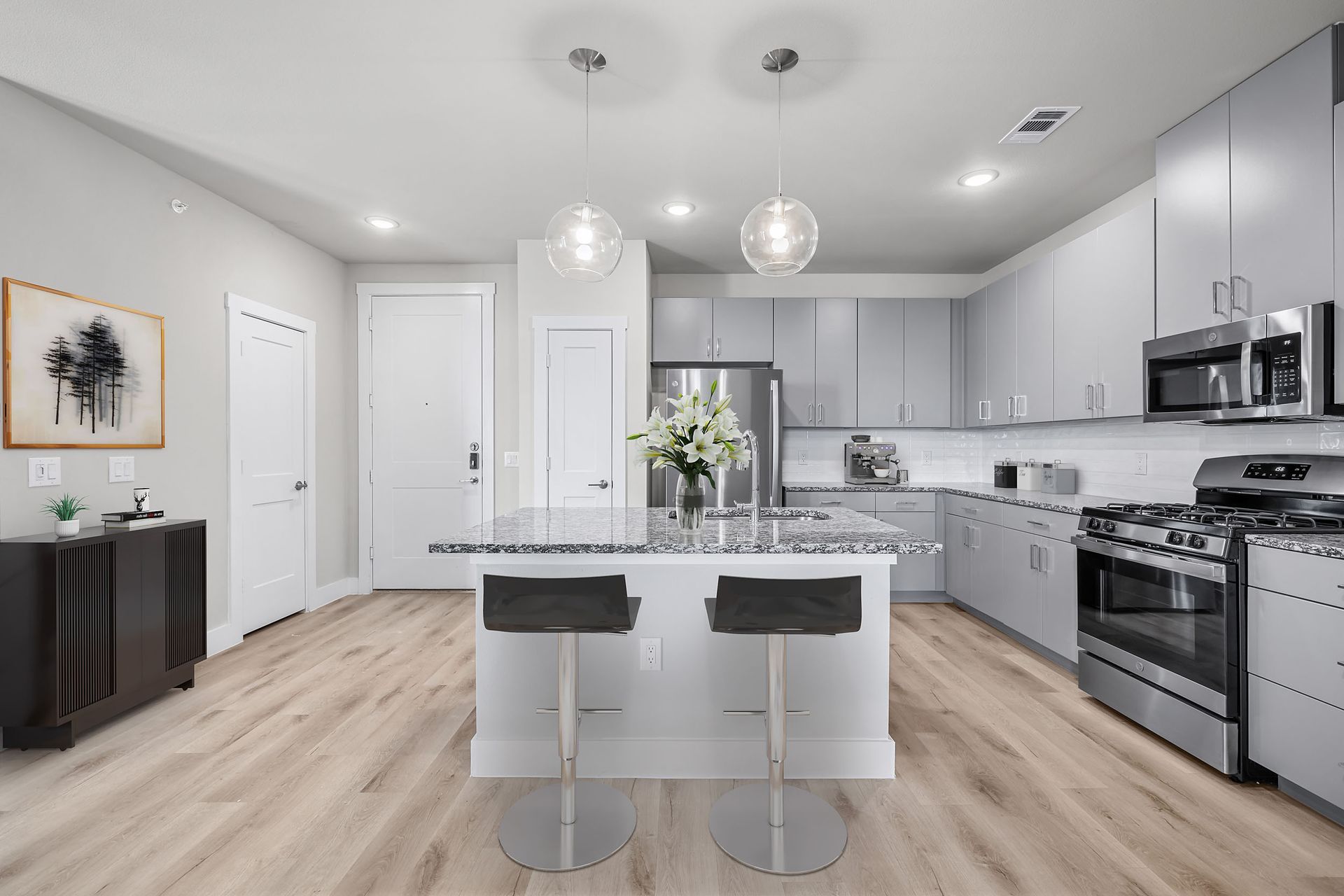 A kitchen with stainless steel appliances and a large island is featured at The Gabriel, which offers apartments near The Domain in Austin.
