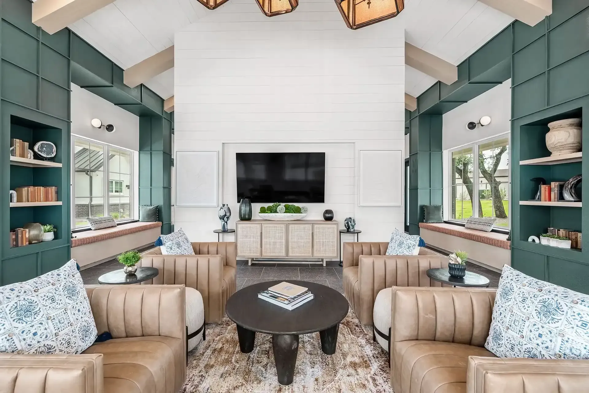 Apartment clubhouse with high ceilings, furnished with sofas, a coffee table, and a flat-screen TV at The Gabriel, which offers Leander apartments near the HEB Center.