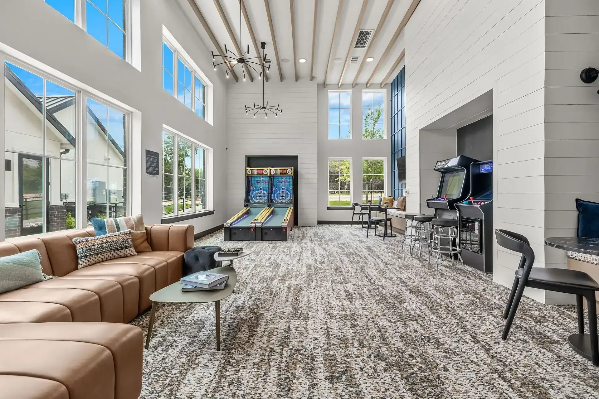 A large apartment building with a courtyard featuring a picnic table and chairs in front of it at The Gabriel, which offers new apartments near Cedar Park.