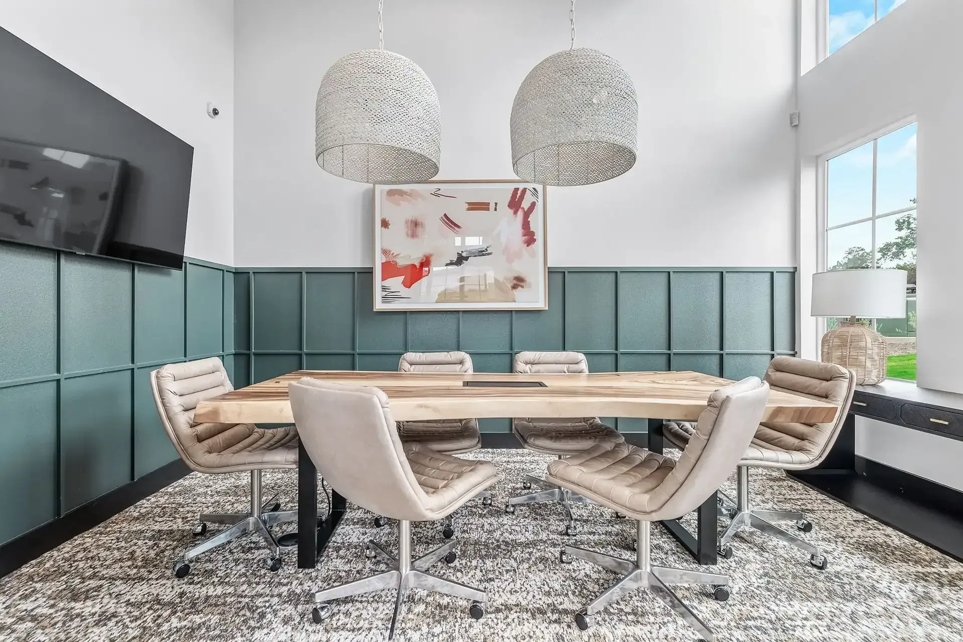 A conference room with a table, chairs, and a television at The Gabriel, which offers apartments near Georgetown.