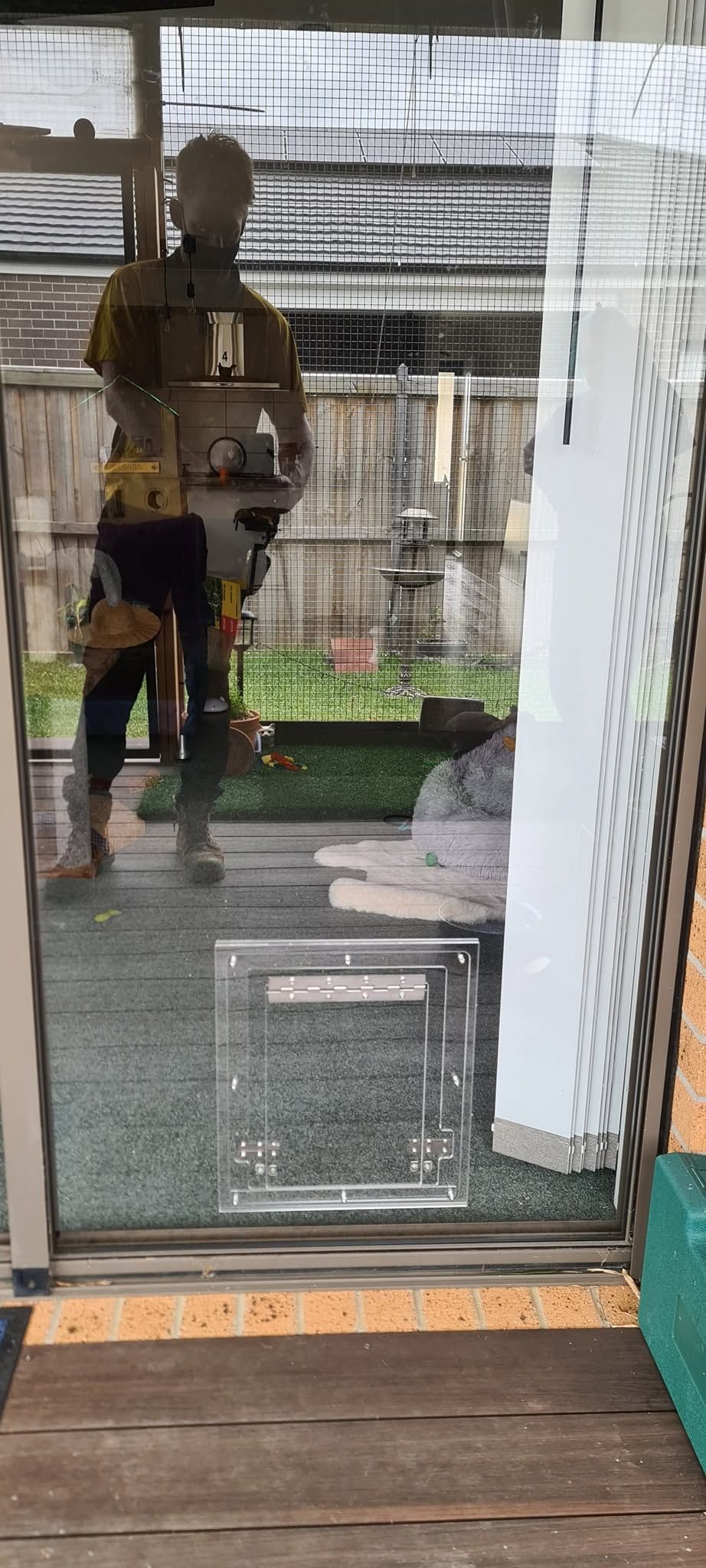 A person is standing in front of a glass door.