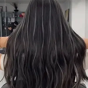 Long wavy black hair seen from behind in a salon mirror