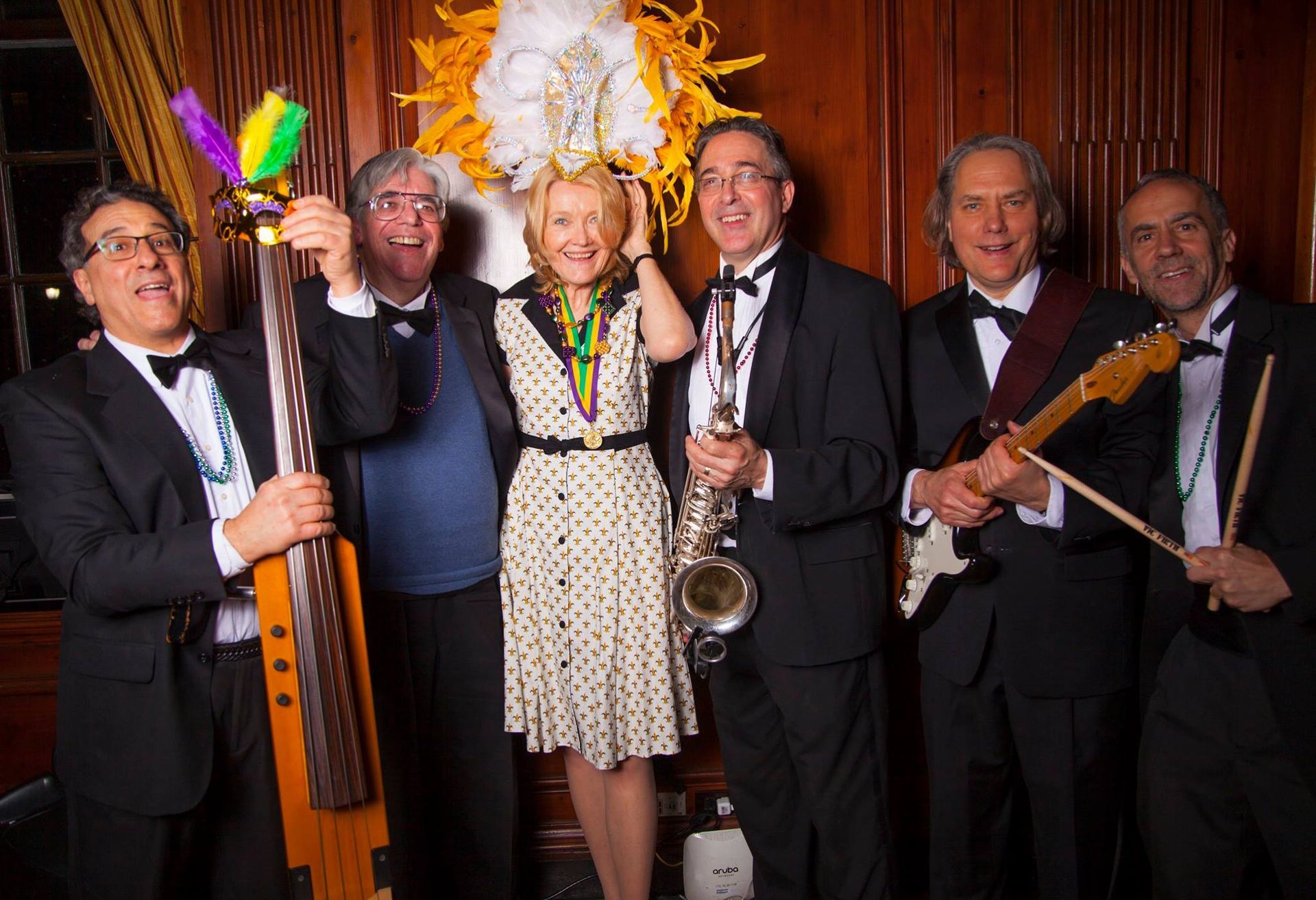 Bales & Gitlin in tuxedos and dresses, with instruments, celebrating.