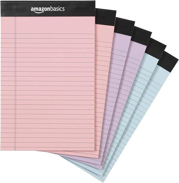 A bunch of lined notebooks are stacked on top of each other.
