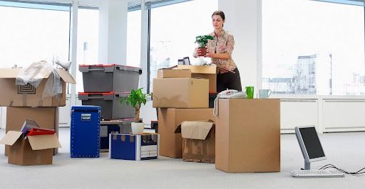 Woman unpacking office boxes with smart moving company tips in mind.