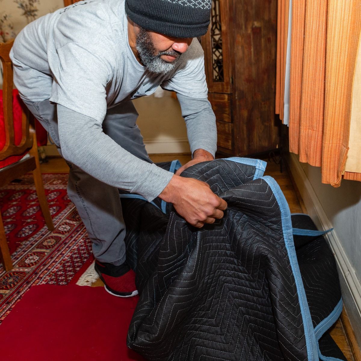 A man with a beard is holding a black bag