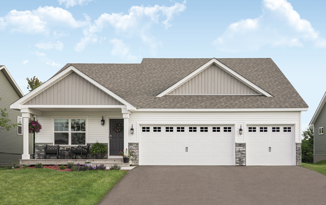 A white house with a gray roof and a driveway in front of it.
