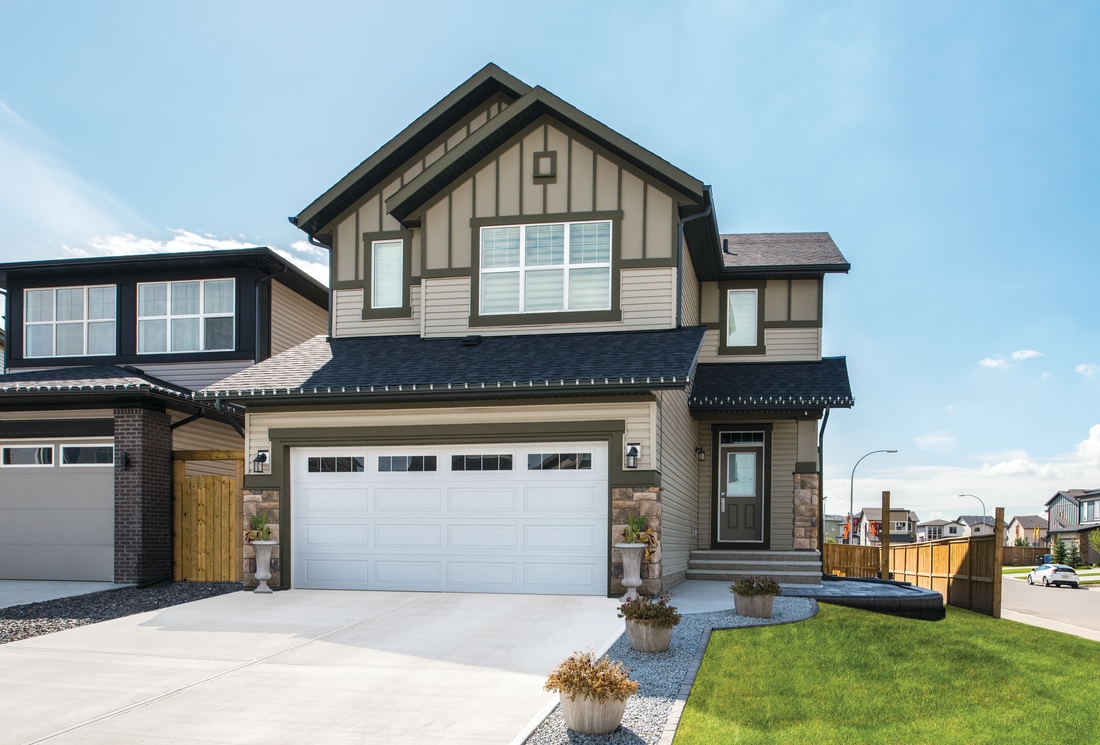 A large house with a garage and a driveway in front of it.