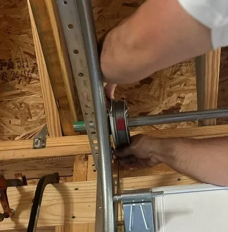 A green garage door with a view of a fence and chairs