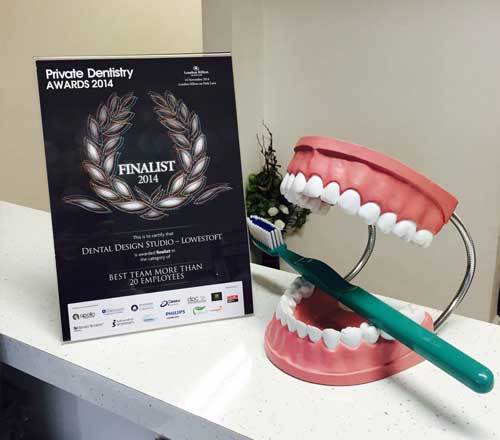 private dentistry awards diploma with a blueprint of human teeth holding a toothbrush thropy