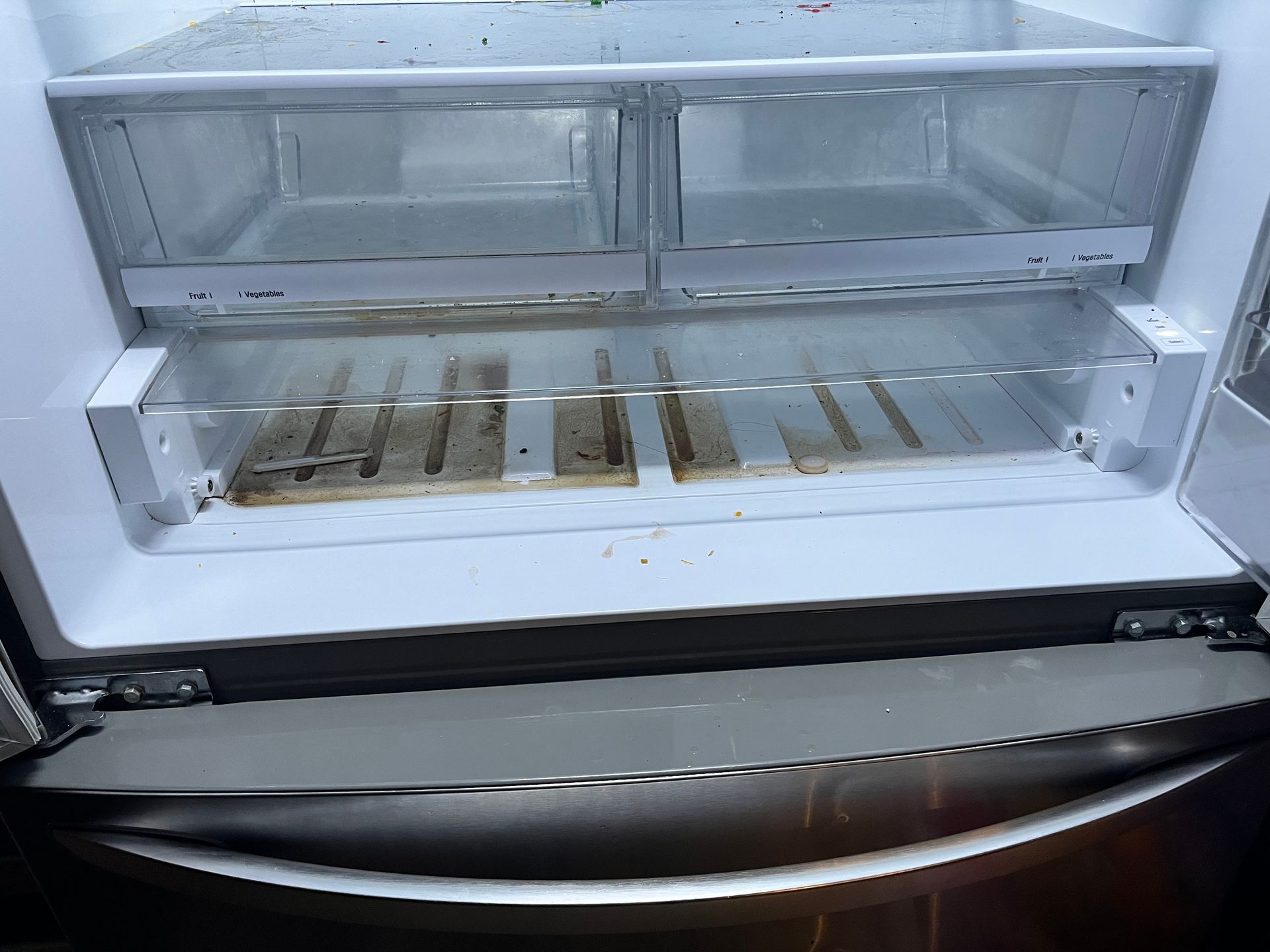 Open refrigerator with dirty produce drawers; stainless steel exterior.