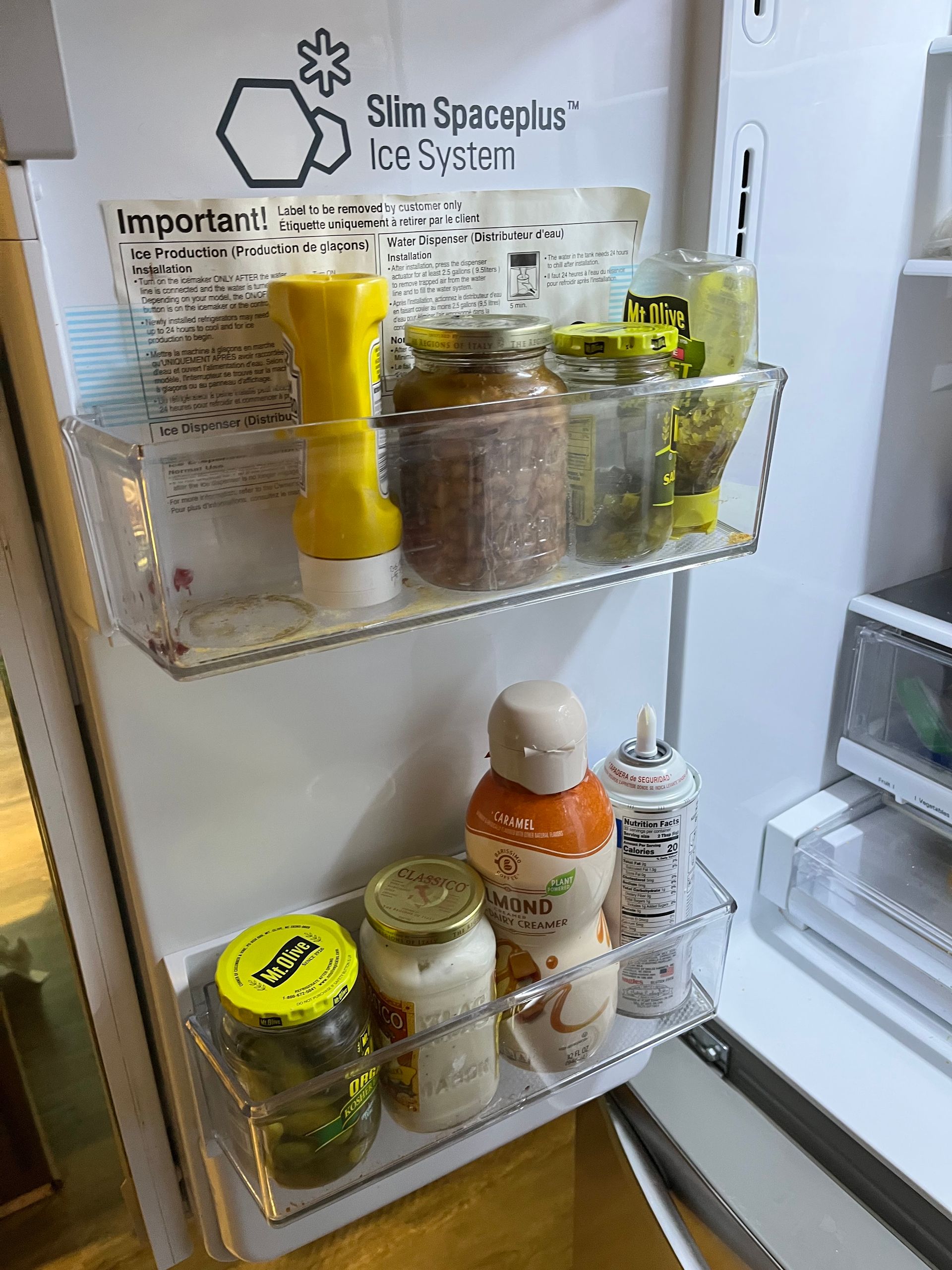 Refrigerator interior with two shelves containing condiments and jars of food. The fridge door is open.