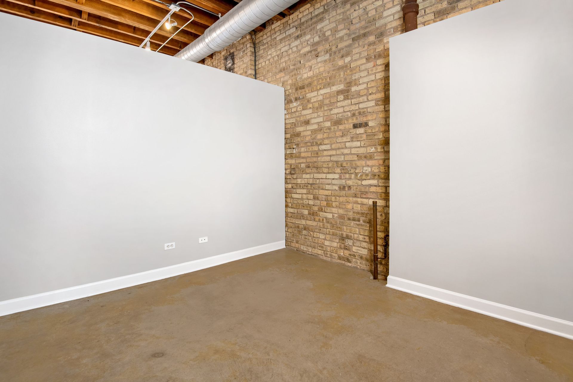 An empty room with a brick wall and white walls at 945 W Fulton Market Apartments.