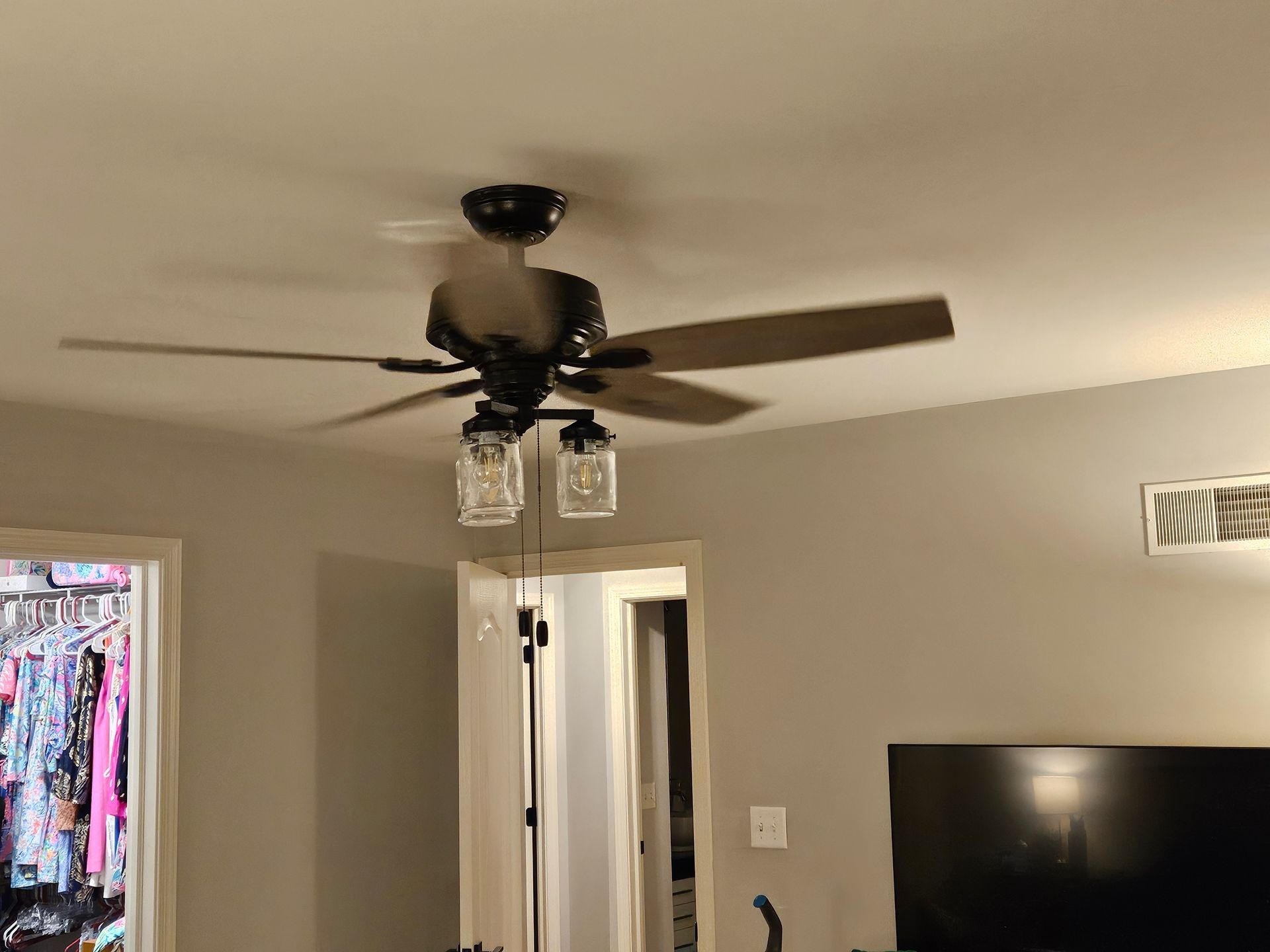 A living room with a ceiling fan and a television.