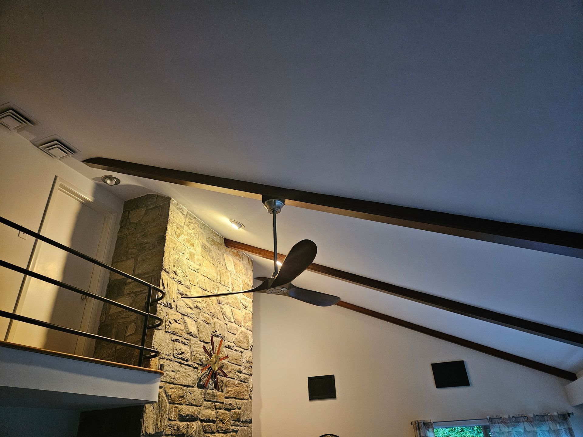 A ceiling fan is hanging from the ceiling of a room
