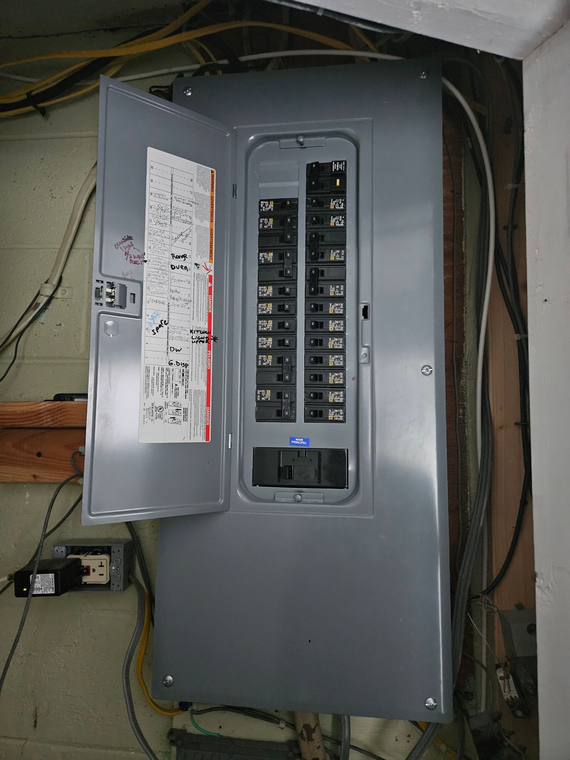 A electrical box with the door open and a lot of wires coming out of it.