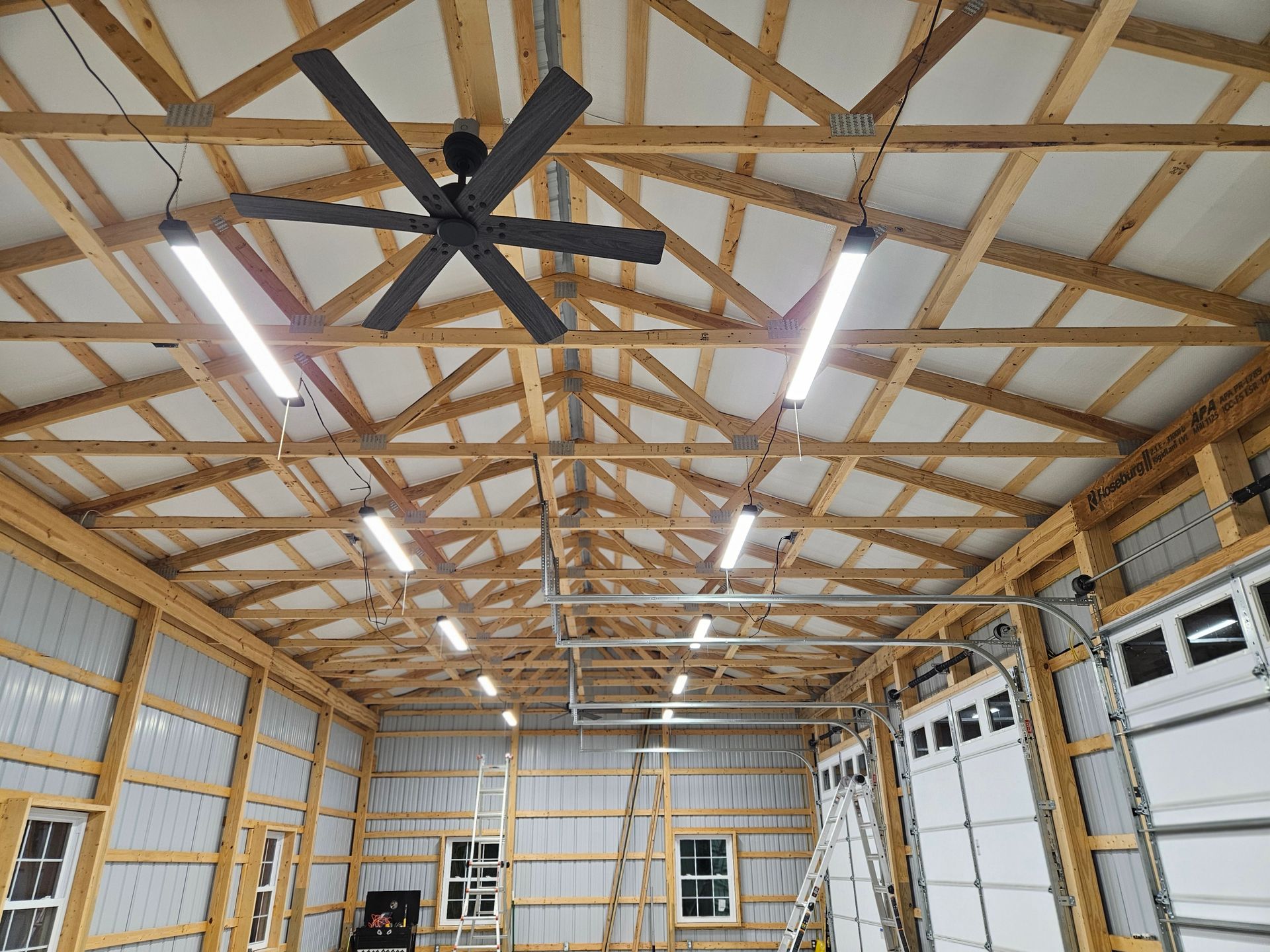The inside of a garage with a ceiling fan and lights.