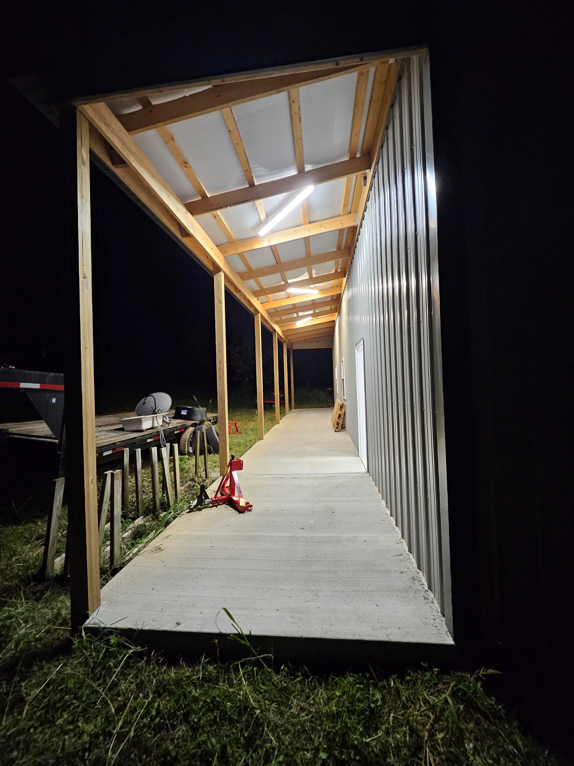 A covered walkway leading to a building at night.
