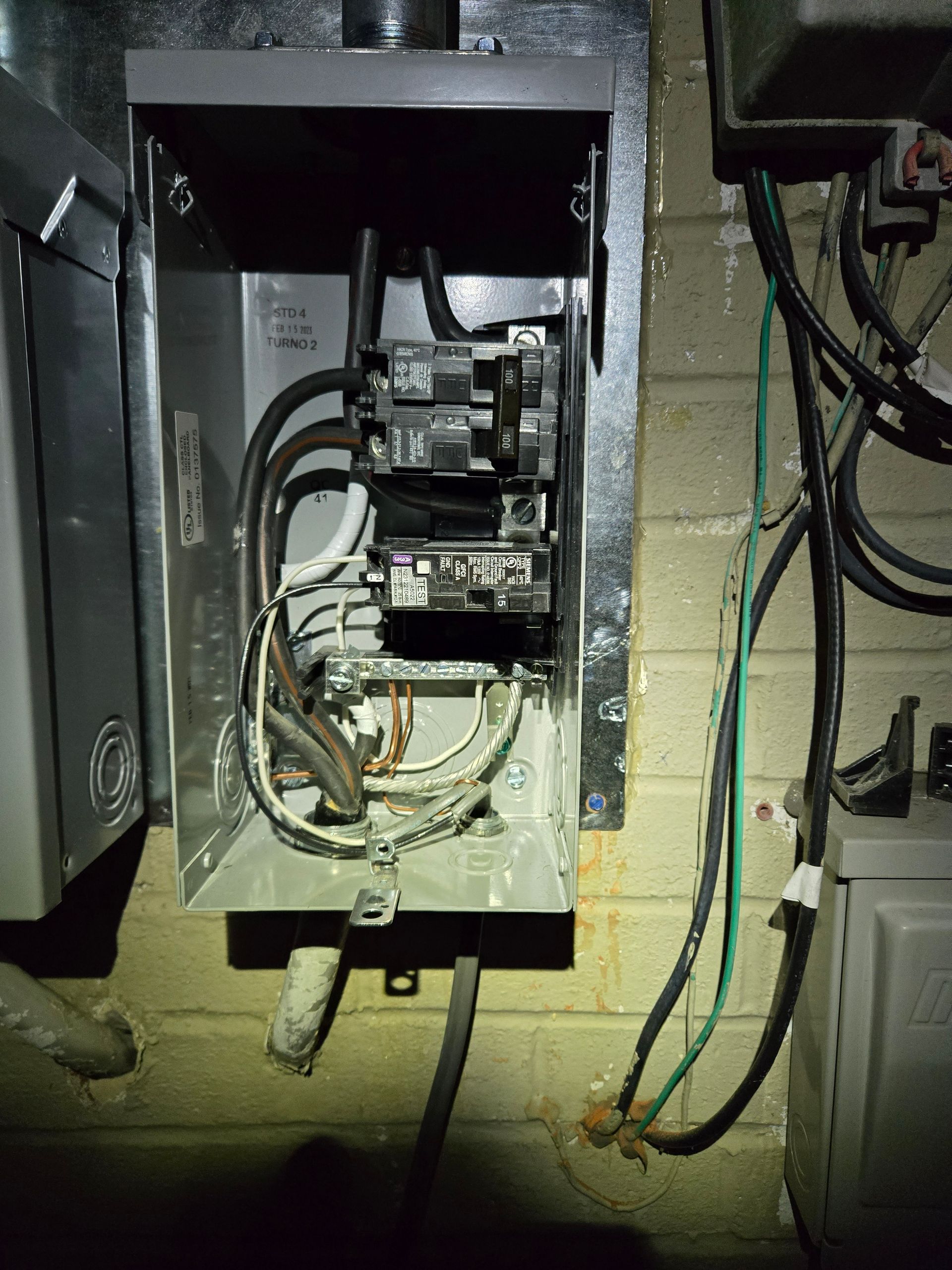 A close up of an electrical box on a brick wall.