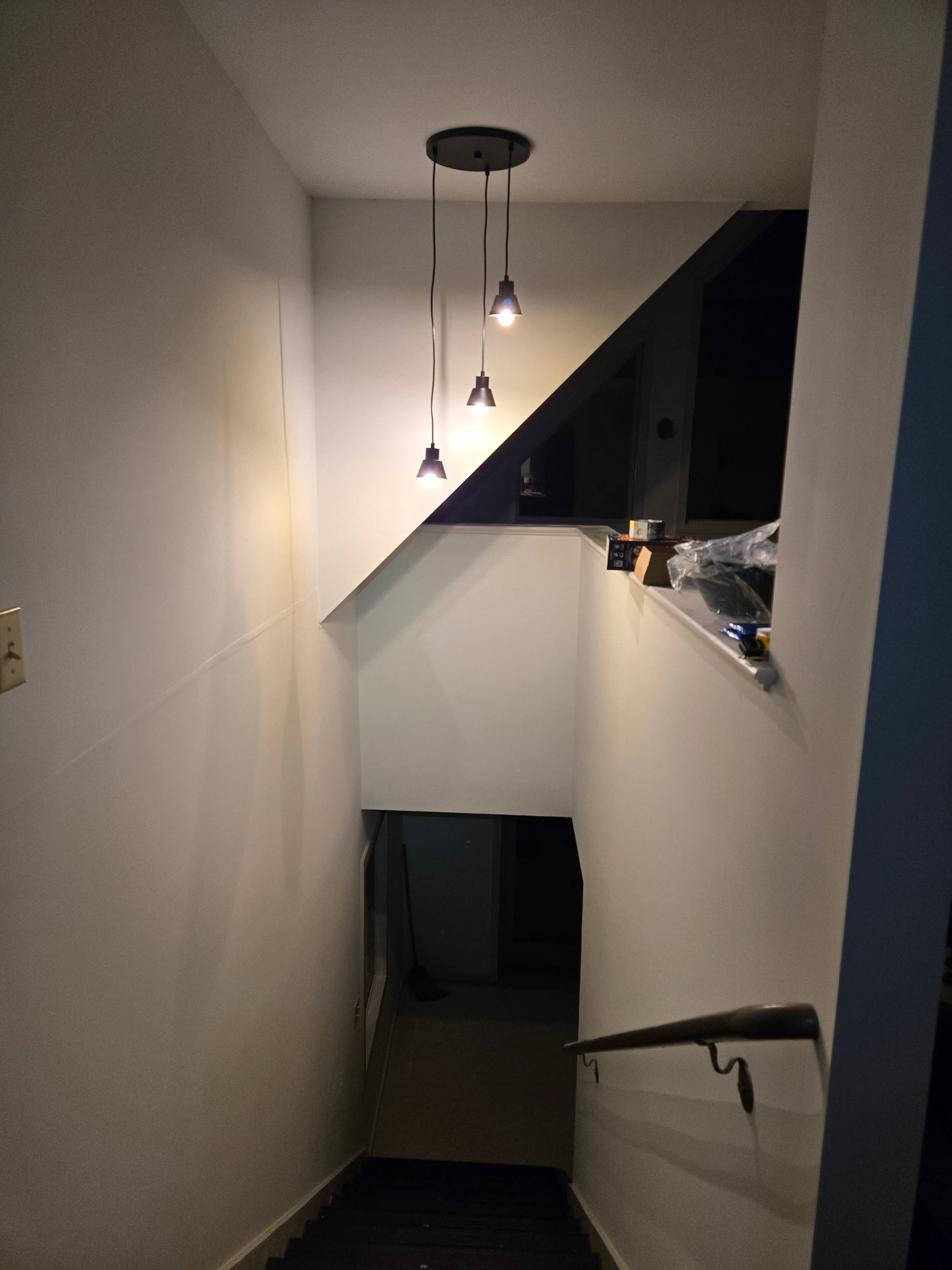 A staircase with lights hanging from the ceiling