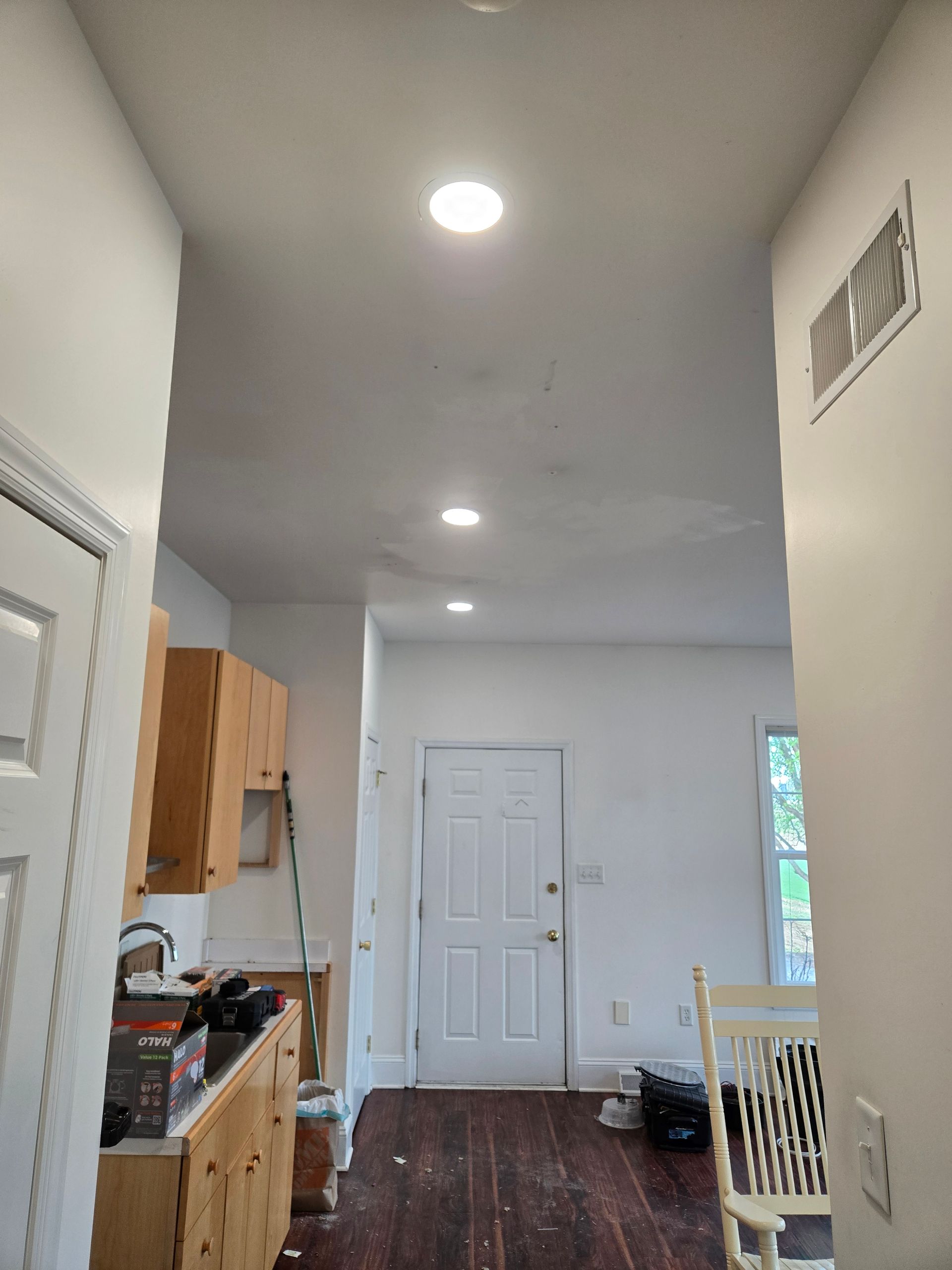 A hallway leading to a kitchen and dining room in a house.