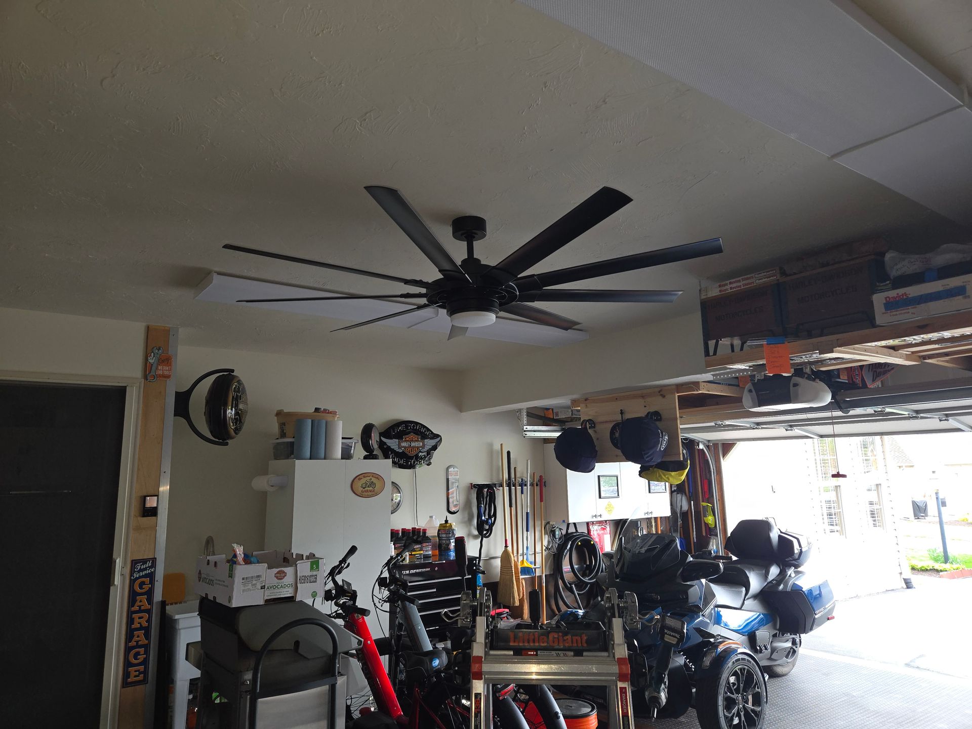 A ceiling fan is hanging from the ceiling of a garage.