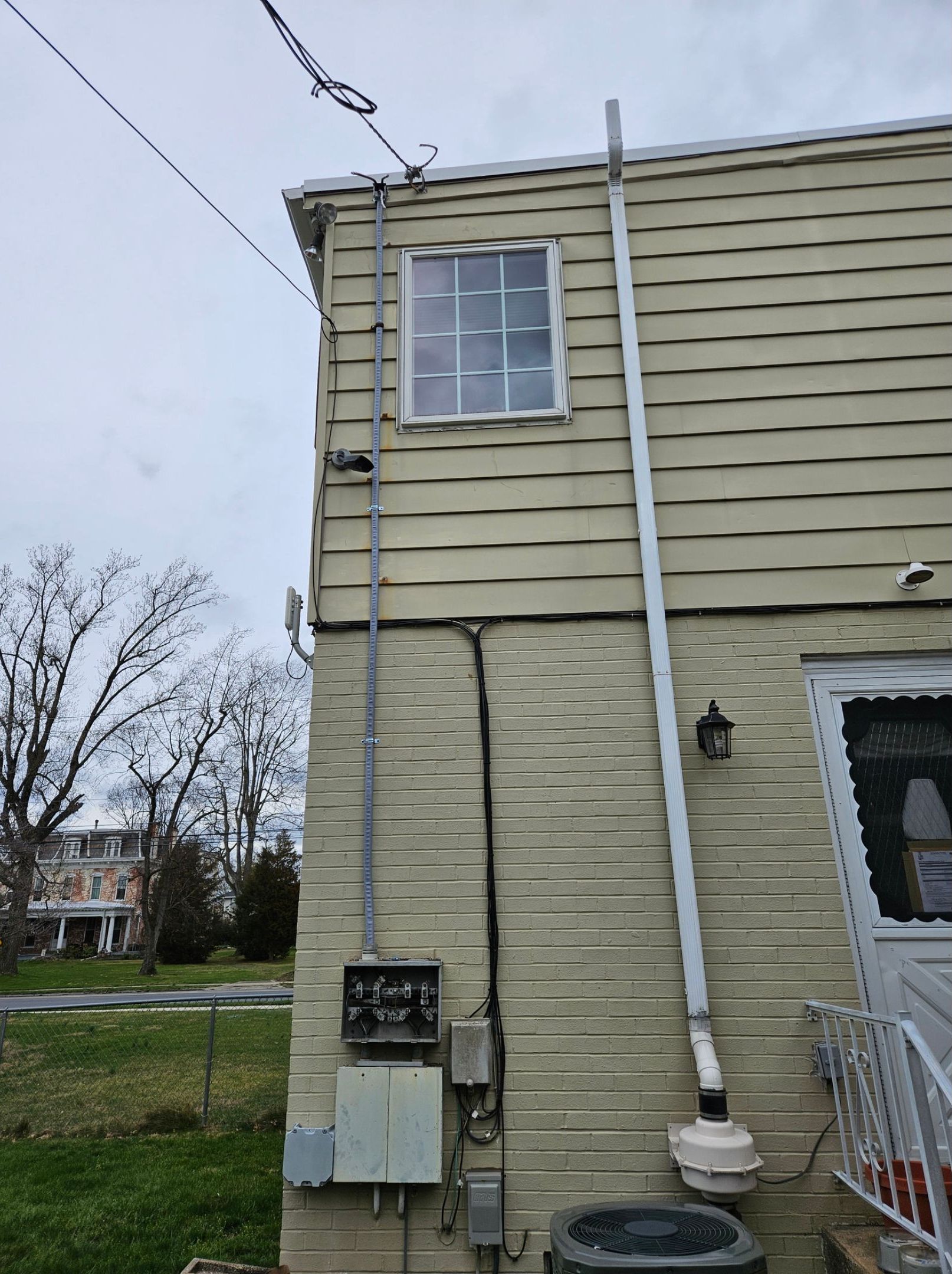 A house with a window and a drain pipe on the side of it.