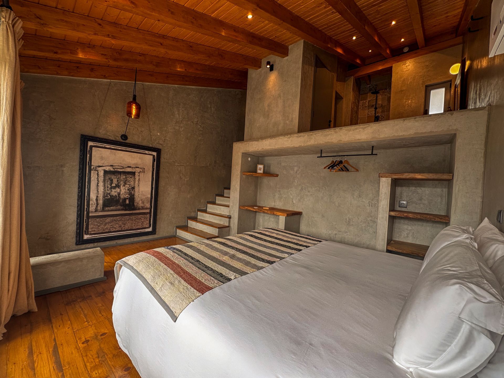 Bedroom with purple bedspread, red pillows, sliding glass door to a balcony, and a doorway to a bathroom.