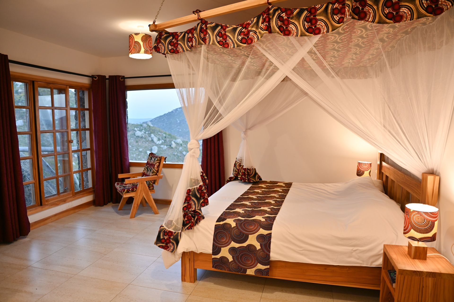 Bedroom with purple bedspread, red pillows, sliding glass door to a balcony, and a doorway to a bathroom.